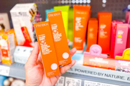 hand holding two orange boxes of Pacifica Baby Serum