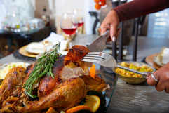 a person carving a thanksgiving turkey