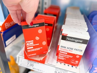 hand grabbing neutrogena stubborn acne patches off a target shelf