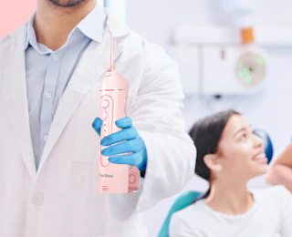 a person holding a pink water flosser