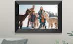 a digital picture frame on a wall with a family and alpacas
