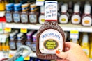 hand holding a bottle of sweet baby rays bbq sauce