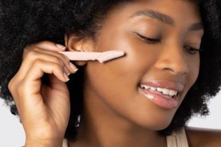 a woman using a dermaplaning tools