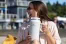 a woman holding a stanley tumbler