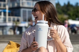 a woman holding a stanley tumbler