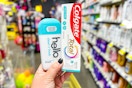 hand holding hello deodorant and colgate toothpaste