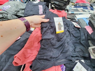 hand holding a pair of dark grey ladies soft shorts