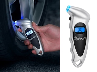 A person checking a tire's pressure with a digital gauge