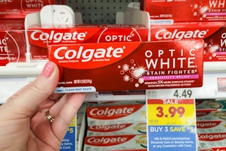 hand holding colgate optic white toothpaste at kroger