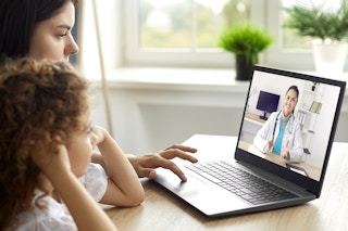mother and child having virtual visit with doctor on laptop