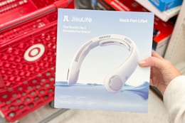 hand holding a neck fan in front of a target cart