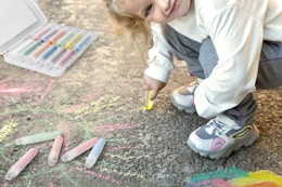 child using chalk on sidewalk