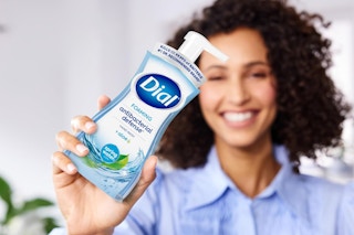 woman holding hand soap bottle in front of bocy