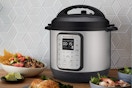 An Instant Pot 6-Quart Duo sits in front of a grey tile backsplash among plates of food.