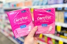 person holding 2 packs of carefree panty liners