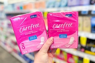 person holding 2 packs of carefree panty liners