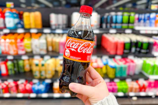 hand holding a bottle of coca cola orange cream soda