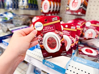 hand holding a febreze small spaces air freshener in front of a target shelf
