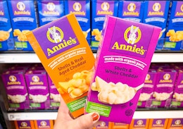 hand holding 2 boxes of annie's mac & cheese in front of target shelf