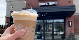 person holding starbucks cinnamon caramel cream nitro cold brew outside entrance