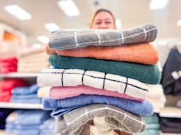 person holding a stack of bath towels in target aisle