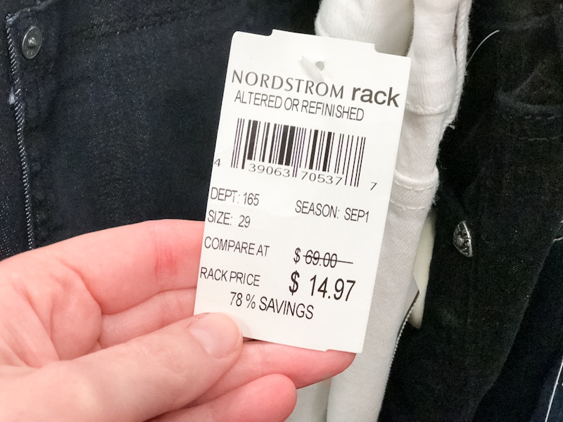 A person holding a price tag that says "Nordstrom Rack Altered or Refinished".