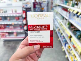 hand holding l'oreal revitalift moisturizer in walgreens