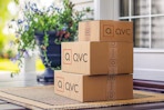 a stack of qvc boxes on a porch 