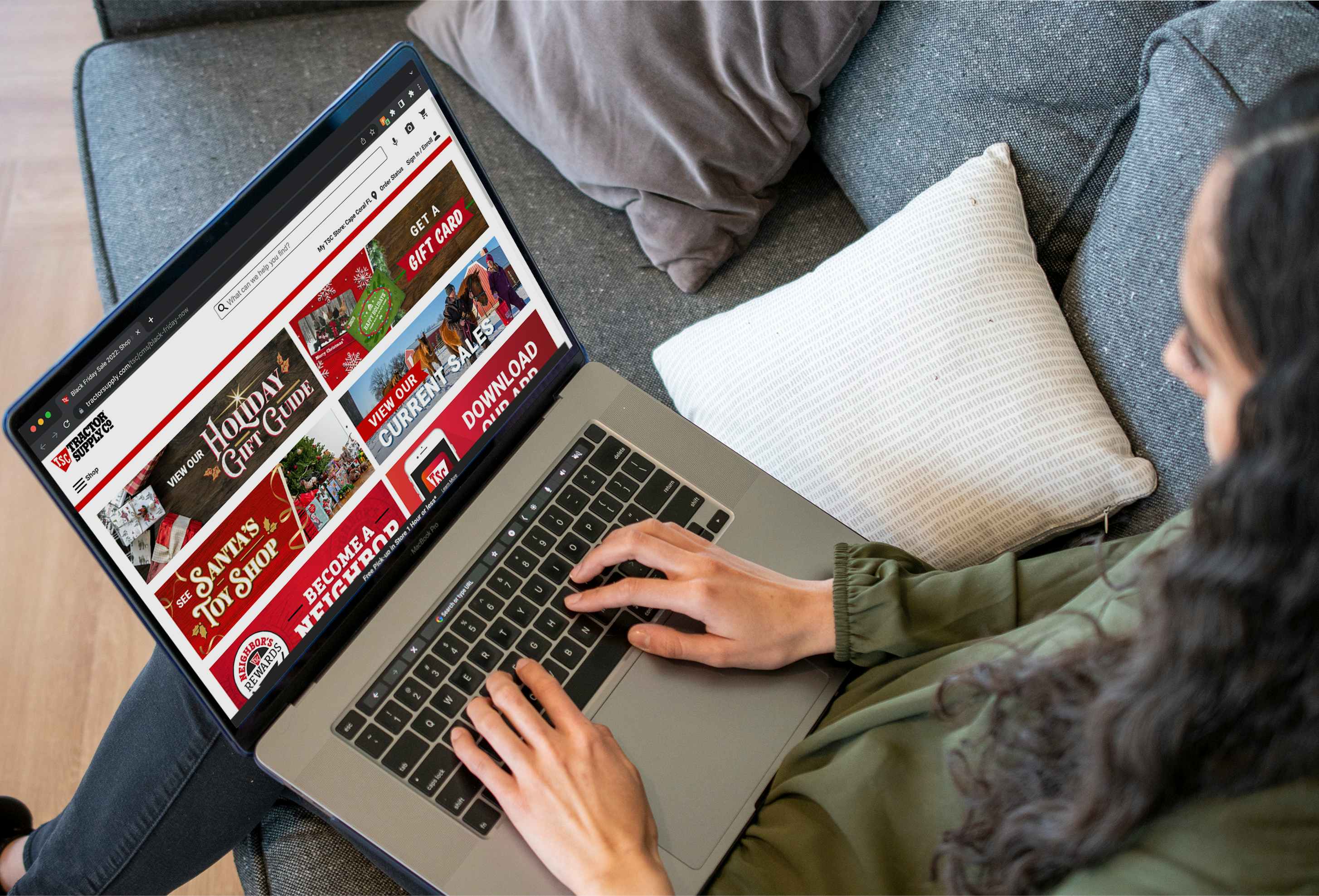 A person using a laptop displaying the Tractor Supply Company website's Black Friday 2022 page.