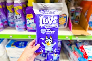 hand holding a trial size pack of luvs diapers