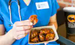 a nurse eating wings from buffalo wild wings