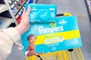 hand holding pampers baby wipes above pampers super pack diapers