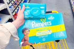 hand holding pampers baby wipes above pampers super pack diapers