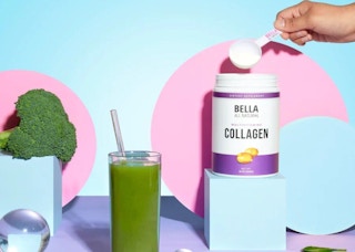 a hand scooping collagen mix on a blue block next to a green smoothie in a cup