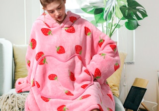 a woman wearing a pink blanket hoodie with strawberries on it