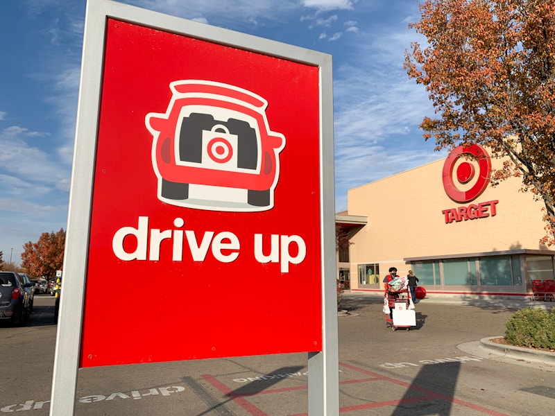 The Target Drive Up sign in the parking lot in front of a Target storefront.