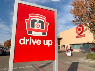 The Target Drive Up sign in the parking lot in front of a Target storefront.