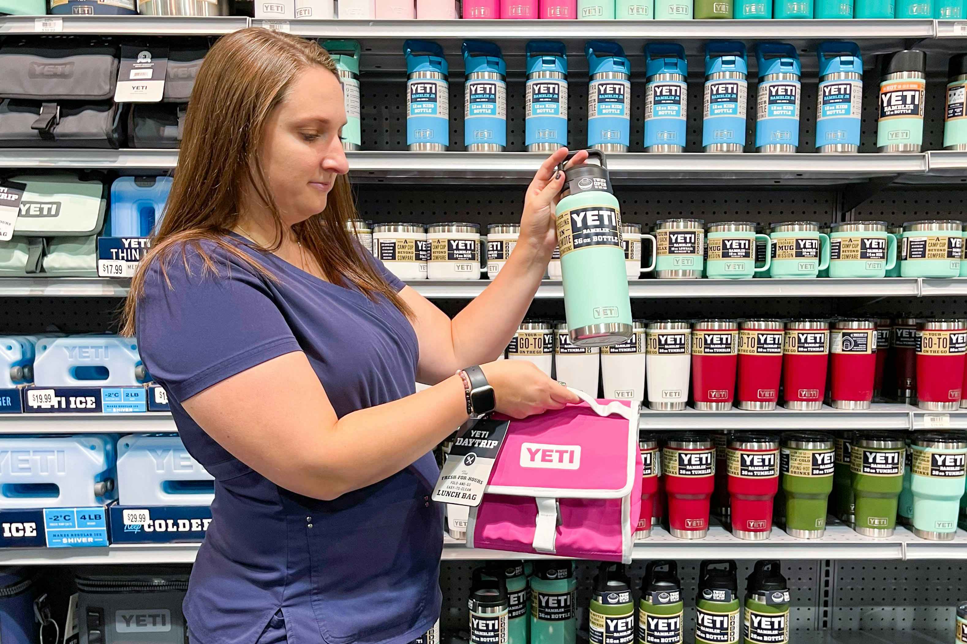 A first responder in scrubs holding YETI items in a store.