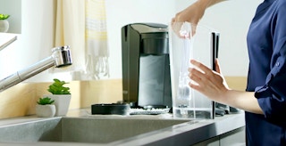 person replacing water filter in keurig coffee maker feature