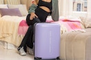 person sitting on bed next to luggage
