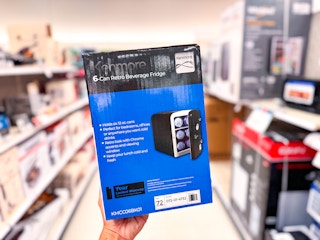 hand holding a blue and black box with the 6-can Kenmore mini fridge