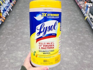 a person holding up lysol wipes in a store