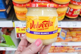 hand holding a jar of velveeta cheese dip