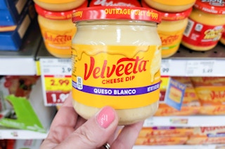 hand holding a jar of velveeta cheese dip