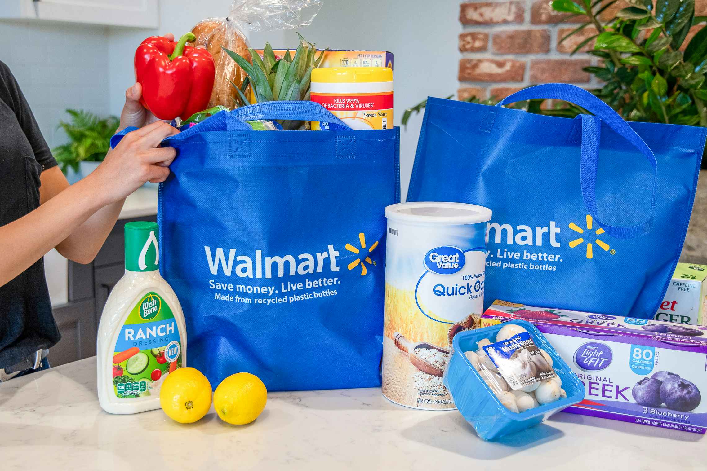 a person unloading groceries out of a walmart bag 