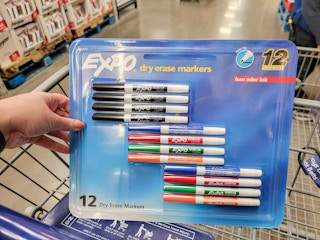hand holding a pack of 12 expo dry erase markers in a cart