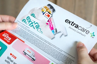 someone looking at a CVS ExtraCare Plus ad