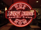 The Krispy Kreme Hot Now sign lit up red.
