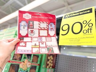 hand holding a pack of Chritmas gift tags in walmart aisle