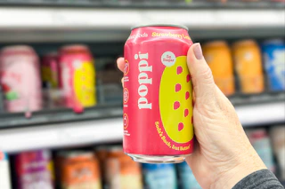 hand holding up a can of poppi soda